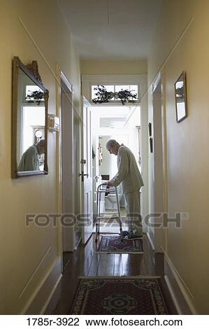 Feeble senior man slowly going down hallway with walker View Large Photo Image Stock Image - Feeble senior man slowly going down hallway with walker. Fotosearch