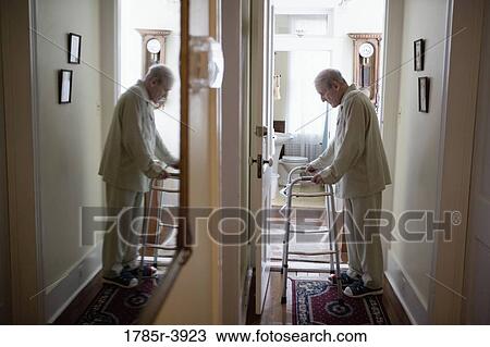 Feeble senior man slowly going down hallway with walker View Large Photo Image Stock Image - Feeble senior man slowly going down hallway with walker. Fotosearch