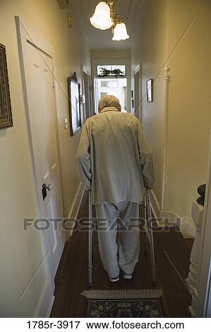 Feeble senior man slowly going down hallway with walker View Large Photo Image Stock Photo - Feeble senior man slowly going down hallway with walker. Fotosearch