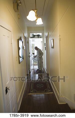 Feeble senior man slowly going down hallway with walker View Large Photo Image Stock Photo - Feeble senior man slowly going down hallway with walker. Fotosearch