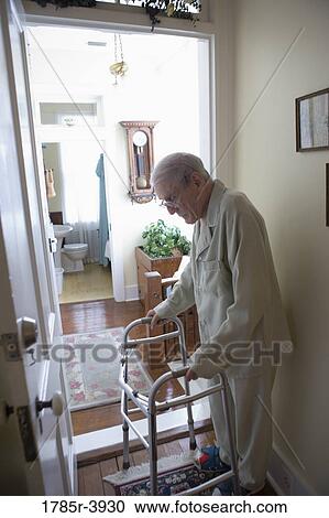 Feeble senior man standing with walker in doorway View Large Photo Image Stock Image - Feeble senior man standing with walker in doorway. Fotosearch