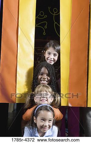 Four giggling girls placing their heads in a vertical row View Large Photo Image Stock Image - Four giggling girls placing their heads in a vertical row. Fotosearch
