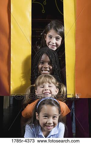 Four giggling girls placing their heads in a vertical row View Large Photo Image Stock Image - Four giggling girls placing their heads in a vertical row. Fotosearch