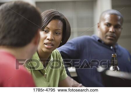 Friends sitting together conversing View Large Photo Image Stock Photography - Friends sitting together conversing. Fotosearch