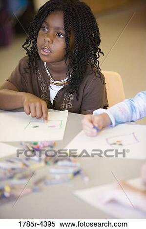 Girl drawing with crayons in an art class View Large Photo Image Stock Photography - Girl drawing with crayons in an art class. Fotosearch