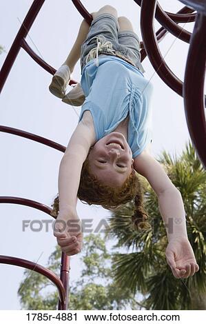 Girl hanging upside-down from jungle gym at a playground View Large Photo Image Stock Image - Girl hanging upside-down from jungle gym at a playground. Fotosearch