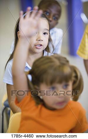 Girl raising hand in a classroom View Large Photo Image Stock Image - Girl raising hand in a classroom. Fotosearch