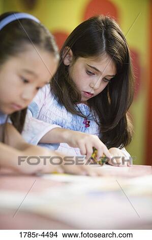 Girls (5-6) drawing with color crayons View Large Photo Image Picture - Girls (5-6) drawing with color crayons. Fotosearch