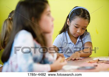 Girls (5-6) drawing with crayons at an art class View Large Photo Image Stock Image - Girls (5-6) drawing with crayons at an art class. Fotosearch