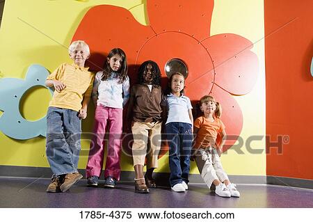 Girls and boy standing against a colorful wall View Large Photo Image Stock Photography - Girls and boy standing against a colorful wall. Fotosearch