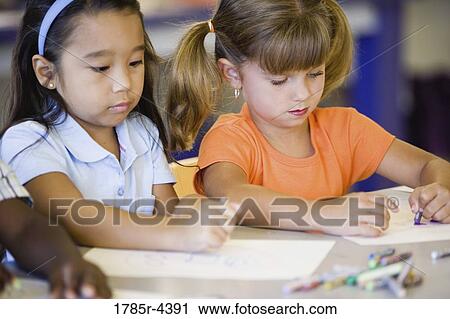 Girls drawing with crayons in an art class View Large Photo Image Stock Image - Girls drawing with crayons in an art class. Fotosearch