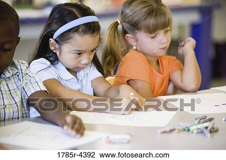 Girls drawing with crayons in an art class View Large Photo Image Stock Image - Girls drawing with crayons in an art class. Fotosearch