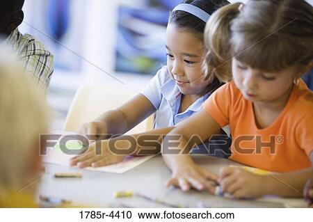 Girls drawing with crayons in an art class View Large Photo Image Stock Image - Girls drawing with crayons in an art class. Fotosearch