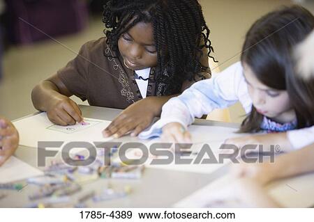 Girls drawing with crayons in an art class View Large Photo Image Stock Photo - Girls drawing with crayons in an art class. Fotosearch