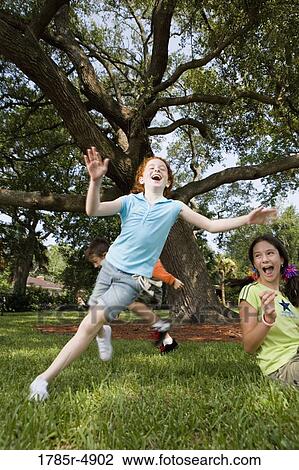 Girls laughing and running hysterically at a park View Large Photo Image Stock Image - Girls laughing and running hysterically at a park. Fotosearch