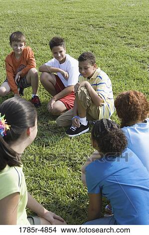 Group of children kneeling on the grass View Large Photo Image Picture - Group of children kneeling on the grass. Fotosearch