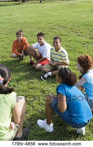 Group of children sitting on the grass View Large Photo Image Stock Photograph - Group of children sitting on the grass. Fotosearch