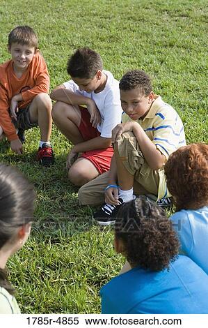 Group of children sitting on the grass View Large Photo Image Stock Photography - Group of children sitting on the grass. Fotosearch