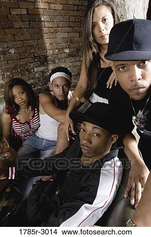 Group of young men and women in hip-hop fashion partying View Large Photo Image Picture - Group of young men and women in hip-hop fashion partying. Fotosearch