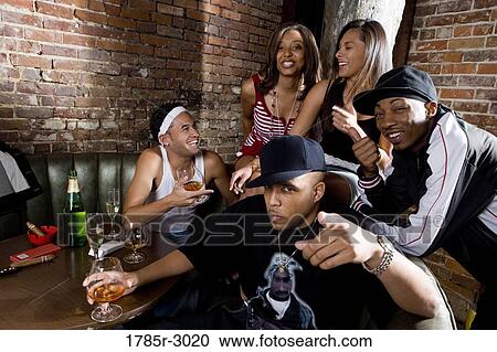 Group of young men and women in hip-hop fashion partying View Large Photo Image Stock Image - Group of young men and women in hip-hop fashion partying. Fotosearch