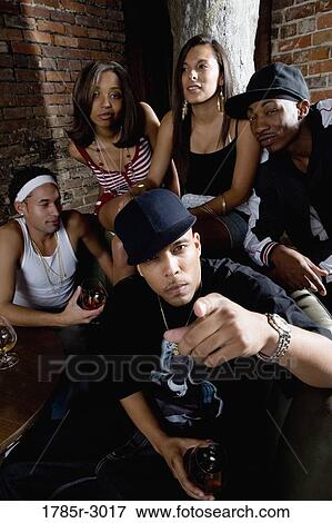 Group of young men and women in hip-hop fashion partying View Large Photo Image Stock Photo - Group of young men and women in hip-hop fashion partying. Fotosearch