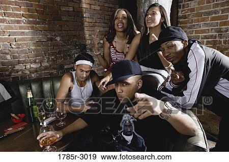 Stock Photo - Group of young men and women in hip-hop fashion partying. Fotosearch