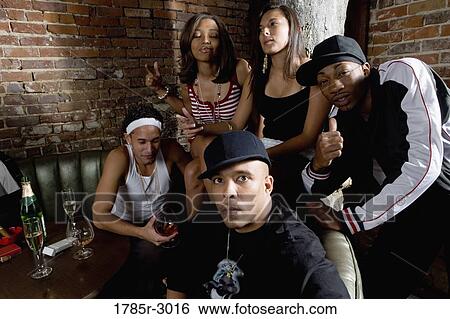 Stock Photograph - Group of young men and women in hip-hop fashion partying. Fotosearch