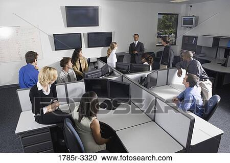 Stock Image - Group of young workers in office having meeting. Fotosearch