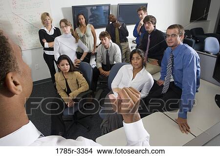 Picture - Group of young workers in office gathered for a meeting. Fotosearch