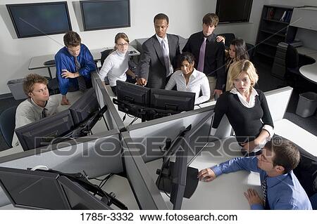 Stock Image - Group of young workers in office working on computers. Fotosearch