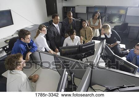 Stock Image - Group of young workers in office working on computers. Fotosearch