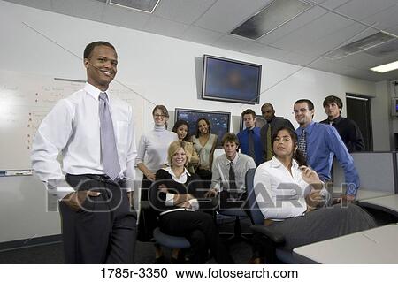 Group of young workers in office gathered for a meeting View Large Photo Image Stock Image - Group of young workers in office gathered for a meeting. Fotosearch