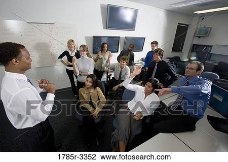 Group of young workers in office gathered for a meeting View Large Photo Image Stock Image - Group of young workers in office gathered for a meeting. Fotosearch