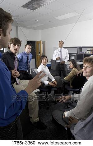 Group of young workers in office gathered for a meeting View Large Photo Image Stock Image - Group of young workers in office gathered for a meeting. Fotosearch
