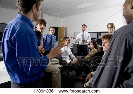 Group of young workers in office gathered for a meeting View Large Photo Image Stock Image - Group of young workers in office gathered for a meeting. Fotosearch