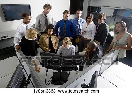Group of young workers in office gathered around computer screen View Large Photo Image Stock Image - Group of young workers in office gathered around computer screen. Fotosearch