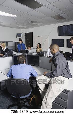 Stock Photo - Group of young workers in office. Fotosearch
