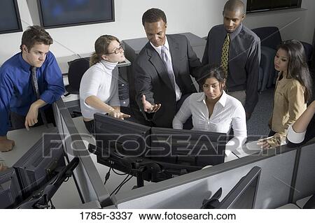 Stock Photo - Group of young workers in office working on computers. Fotosearch