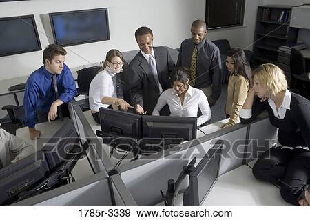 Stock Photo - Group of young workers in office working on computers. Fotosearch