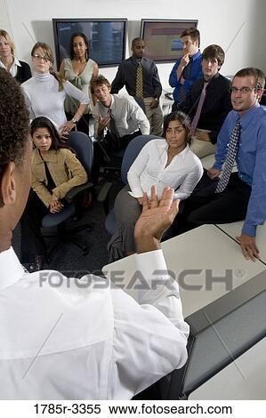 Stock Photography - Group of young workers in office gathered for a meeting. Fotosearch