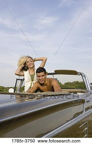 Happy and cheerful young couple sitting in antique convertible car View Large Photo Image Stock Image - Happy and cheerful young couple sitting in antique convertible car. Fotosearch