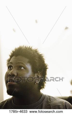 Stock Image - Head-shot of a young man looking up. Fotosearch