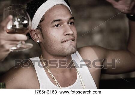 Head-shot of young man in hip-hop fashion holding cognac glass View Large Photo Image Stock Photo - Head-shot of young man in hip-hop fashion holding cognac glass. Fotosearch