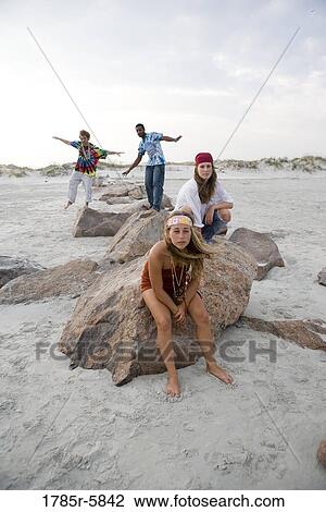 Stock Image - Hippies hanging out at the beach. Fotosearch