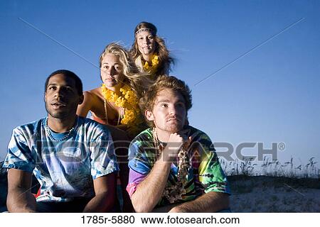 Stock Image - Hippies hanging out at the beach. Fotosearch