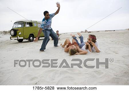 Stock Photo - Hippies hanging out at the beach. Fotosearch