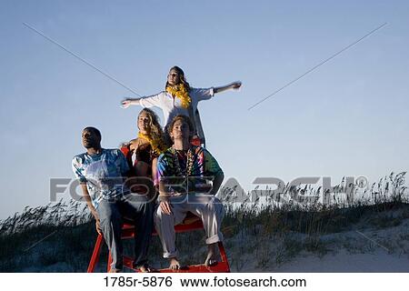 Stock Photograph - Hippies hanging out at the beach. Fotosearch