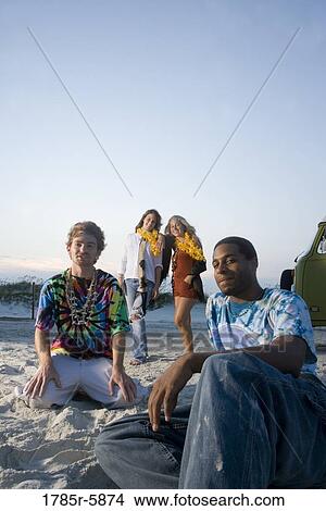 Hippies sitting on sand at beach at dusk View Large Photo Image Picture - Hippies sitting on sand at beach at dusk. Fotosearch