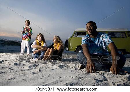 Hippies sitting on sand at beach at dusk View Large Photo Image Stock Image - Hippies sitting on sand at beach at dusk. Fotosearch