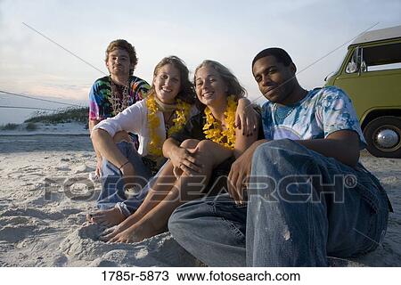 Hippies sitting on sand at beach at dusk View Large Photo Image Stock Image - Hippies sitting on sand at beach at dusk. Fotosearch